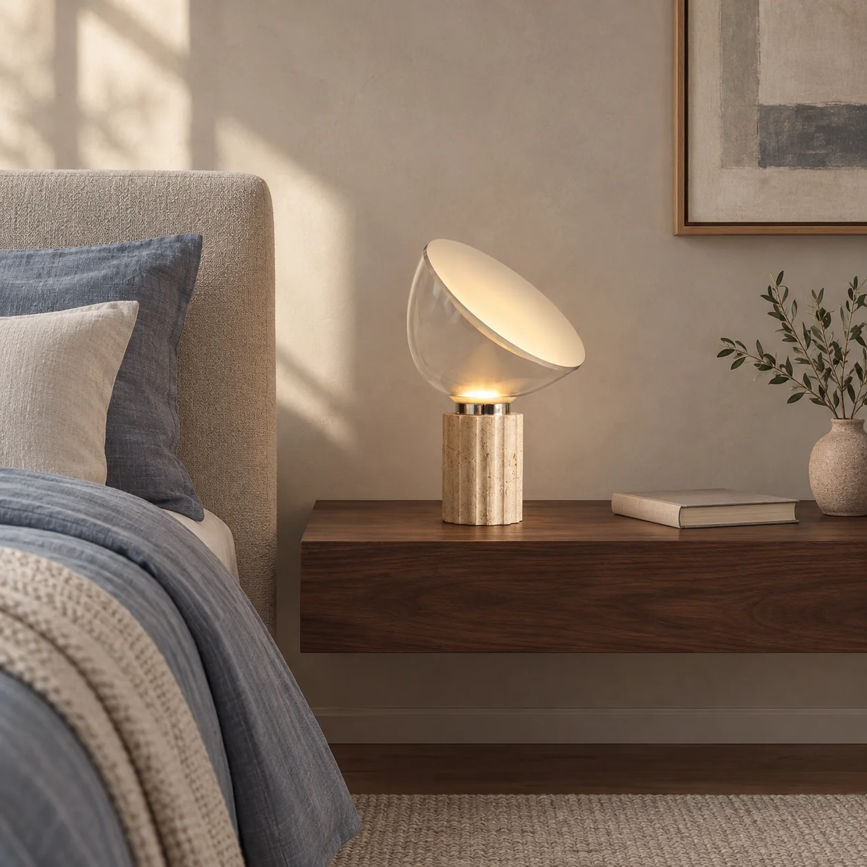 Small travertine glass table lamp on a broad bedside table with clear space around the shade