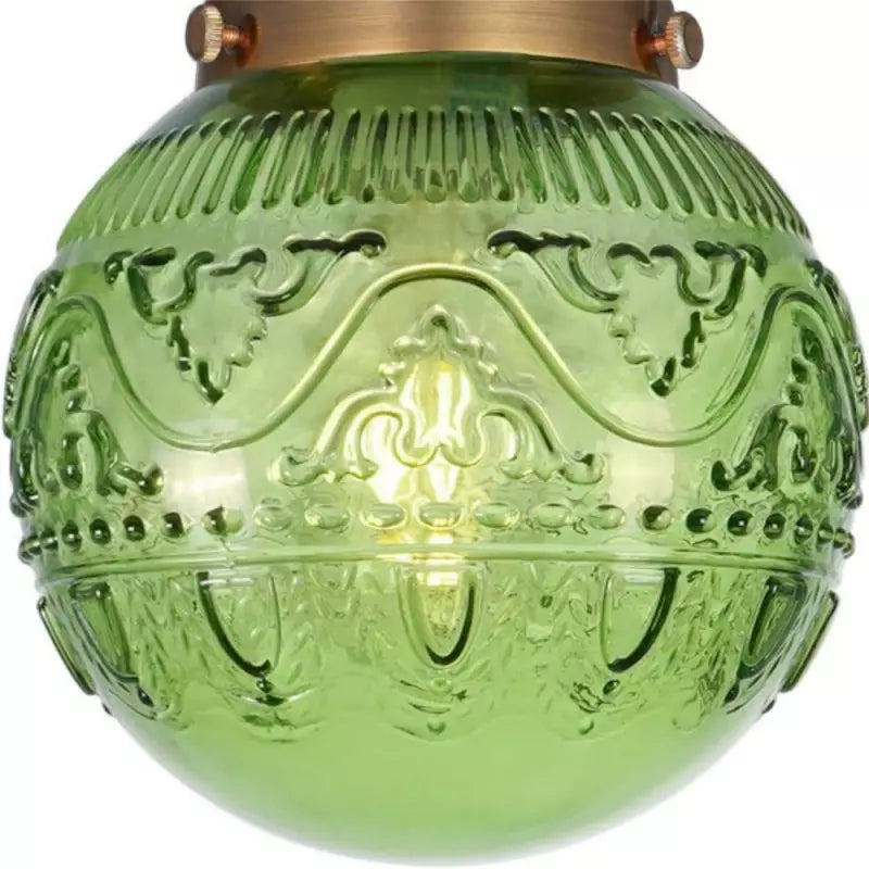 Green engraved glass globe with brass ceiling mount detail