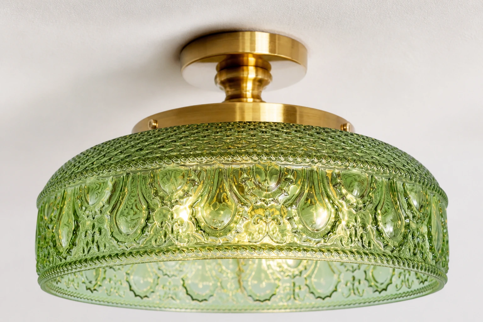 Close material view of the pressed green glass texture and gold metal holder