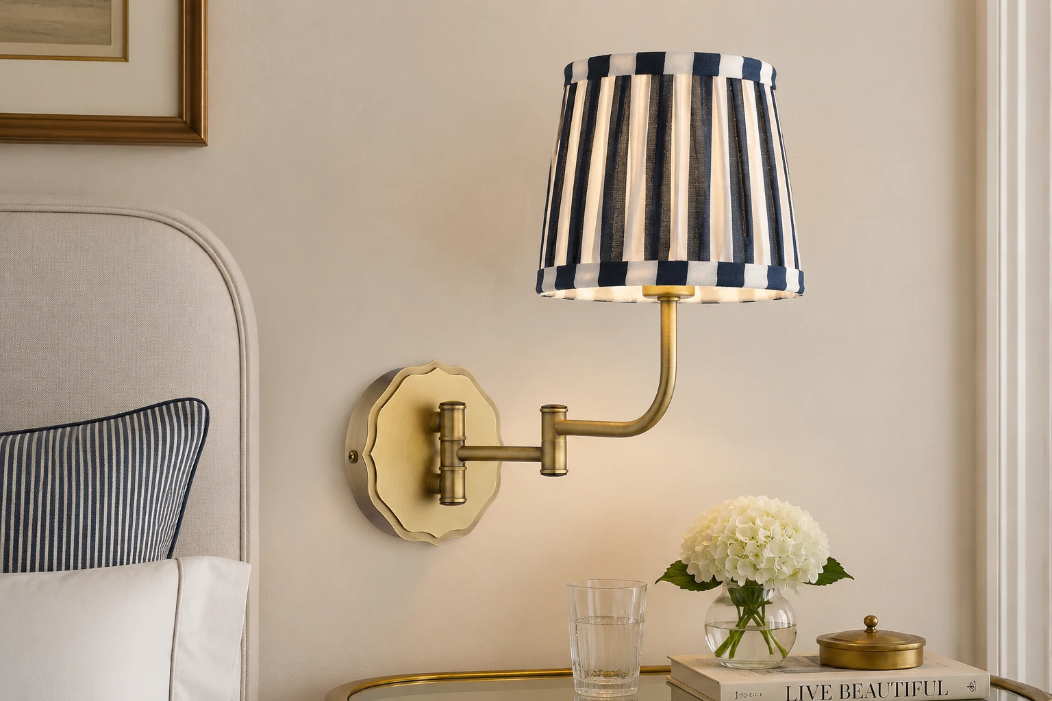 Denwick antique brass wall light with satin blue striped shade beside a bed