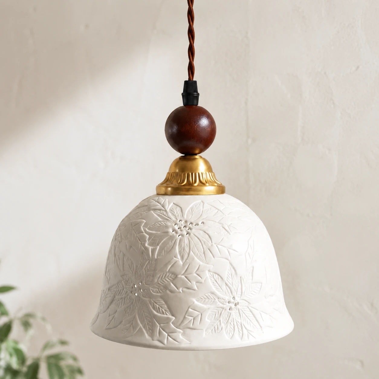 Close view of the raised floral and leaf relief on the white ceramic shade