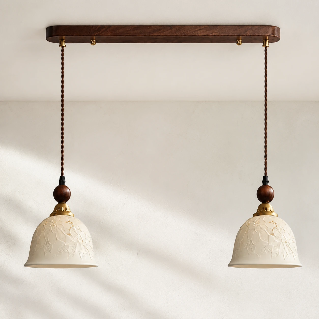 Walnut canopy, warm brass fittings and brown textile-covered suspension cords