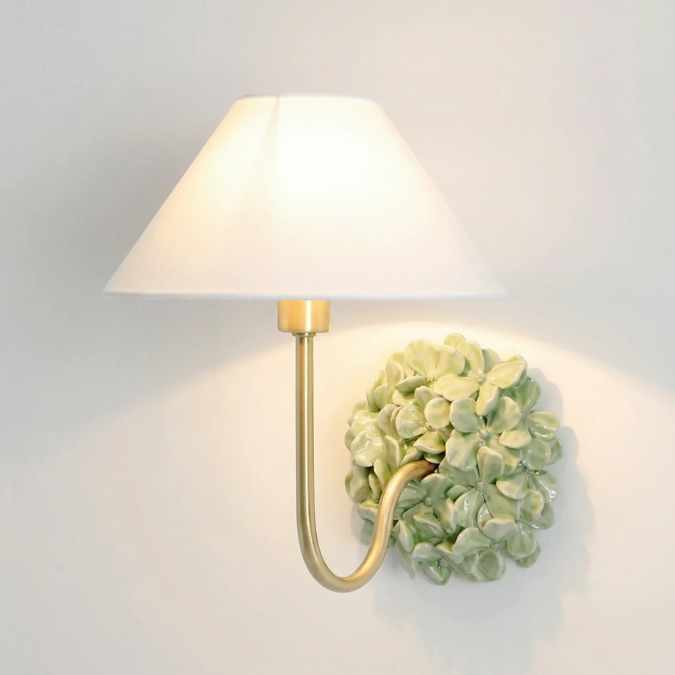 Light Green Florienne floral wall sconce with an ivory linen shade