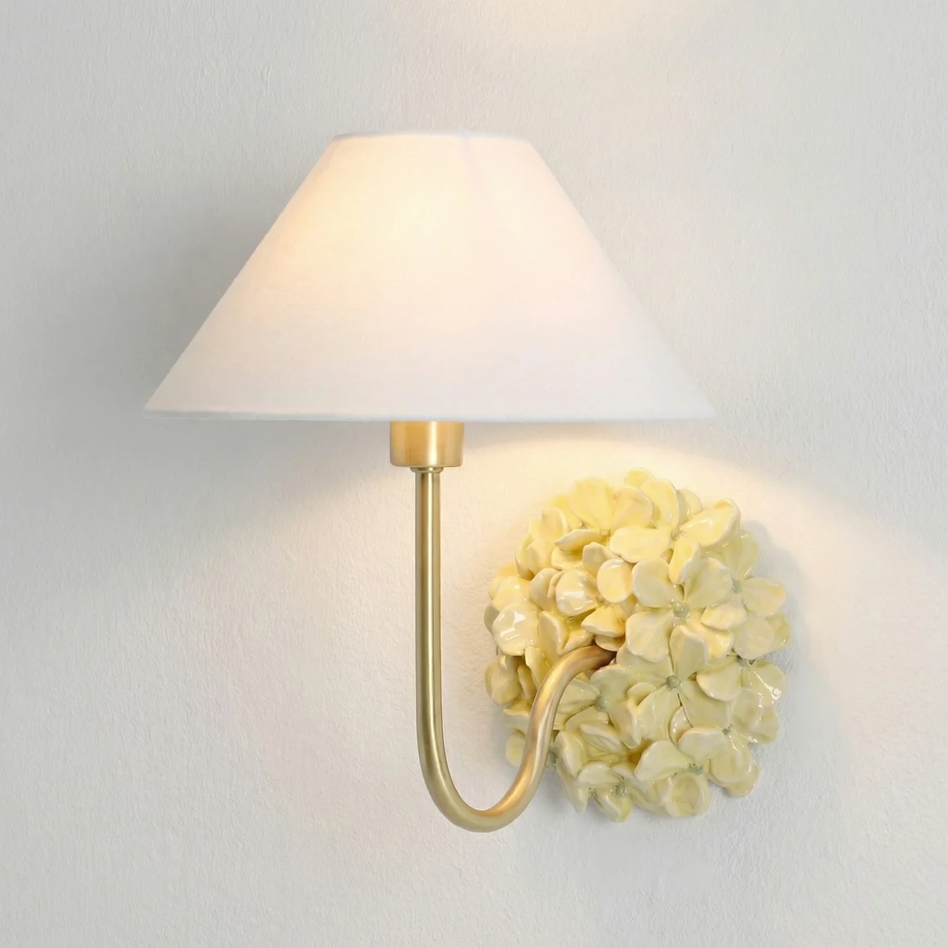 Yellow Florienne floral wall sconce with an ivory linen shade