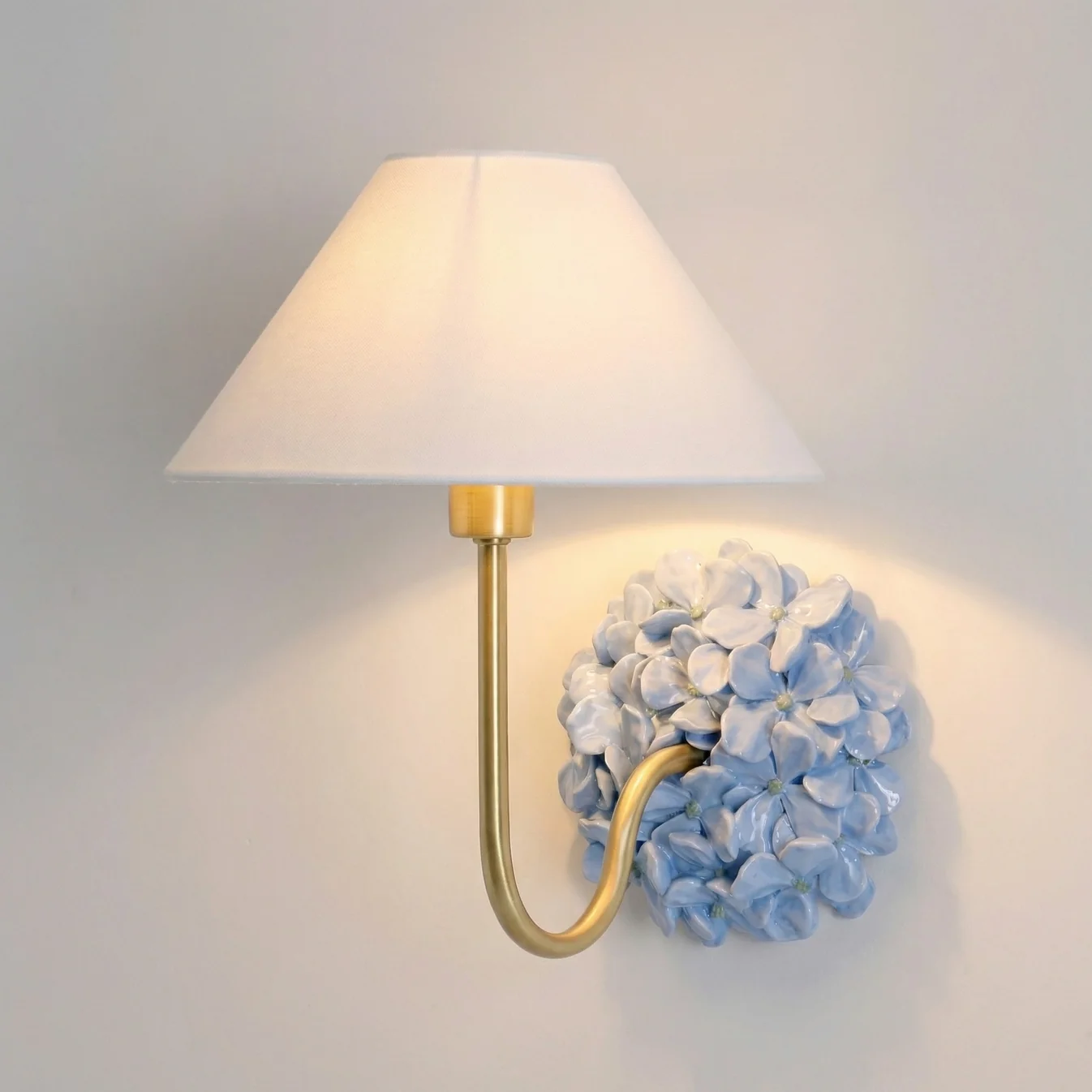 Blue Florienne floral wall sconce with an ivory linen shade