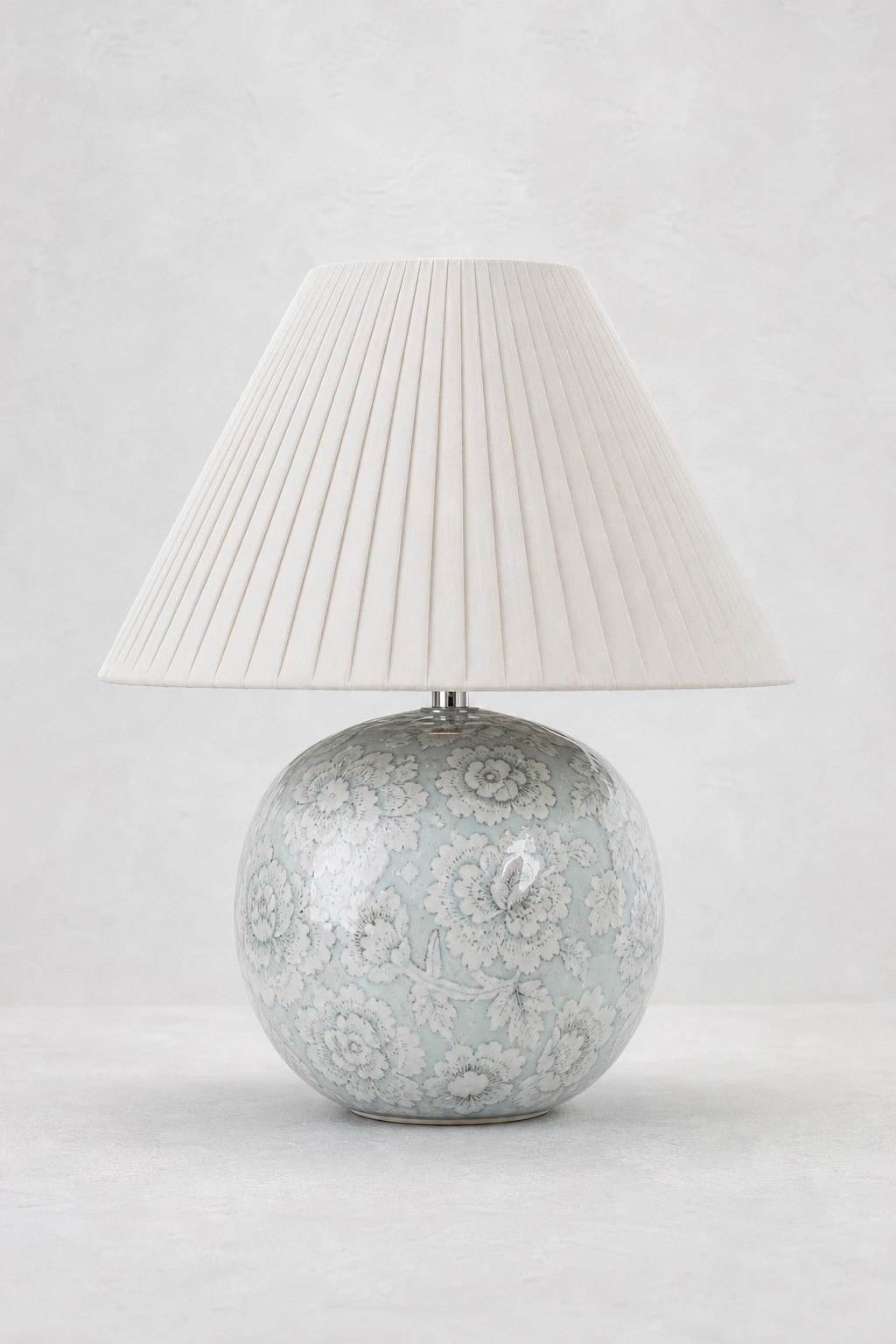 Montford blue floral ceramic table lamp on a pearl-white studio background