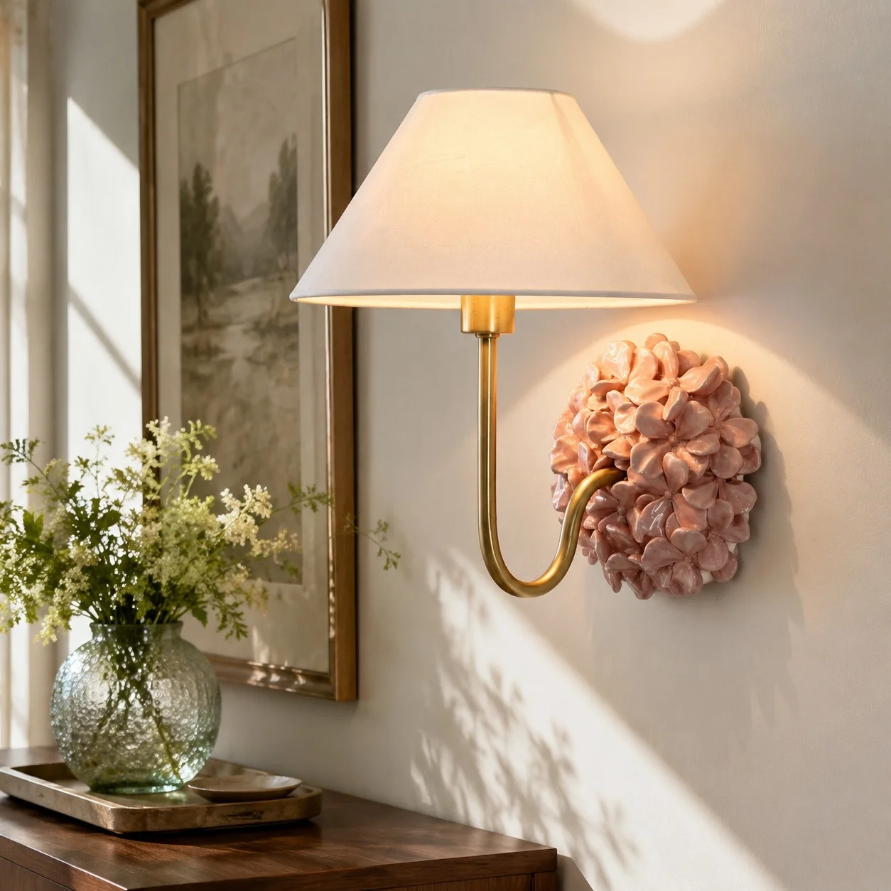 Pink Florienne wall sconce beside framed artwork above an entryway console