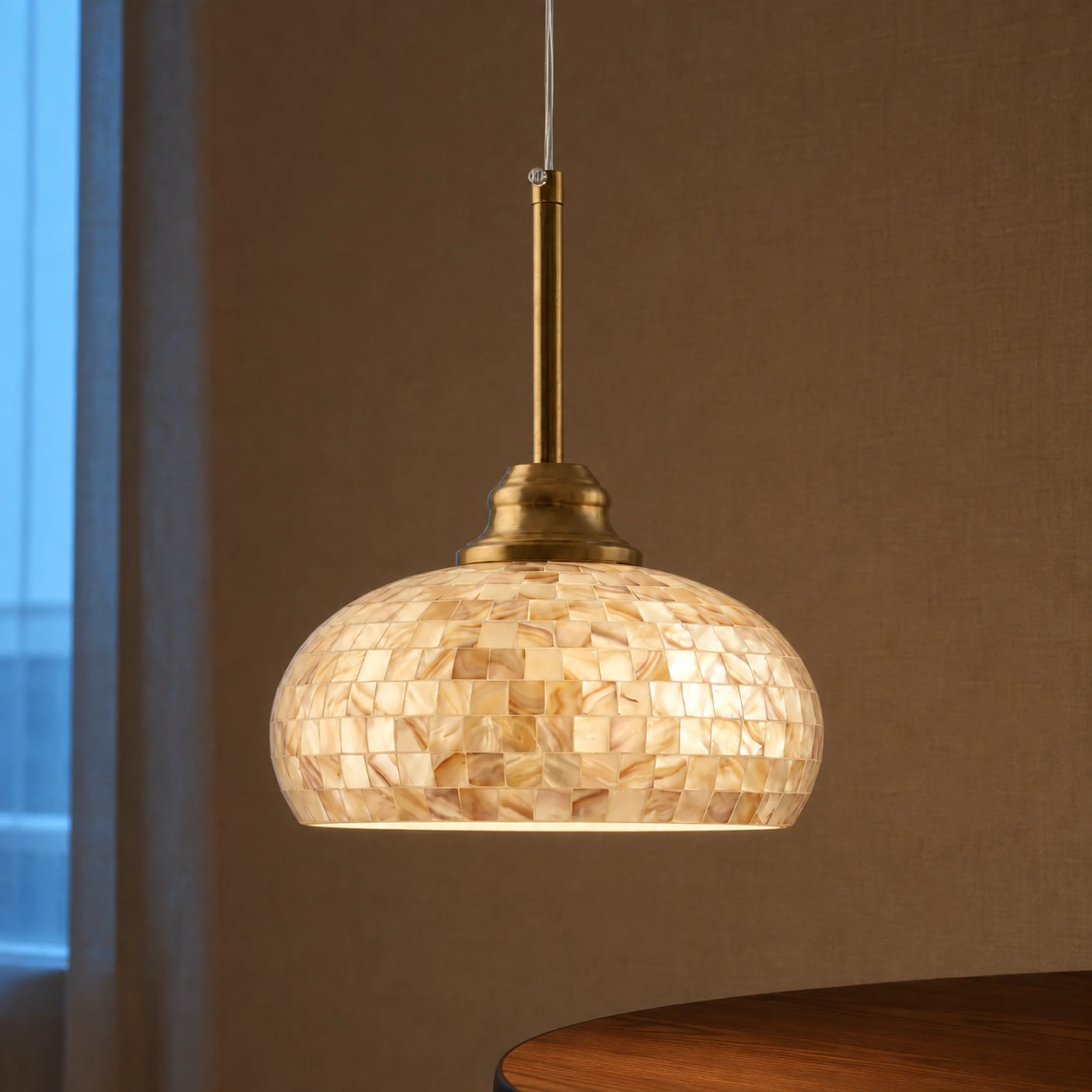 Brass mother-of-pearl pendant glowing in the evening