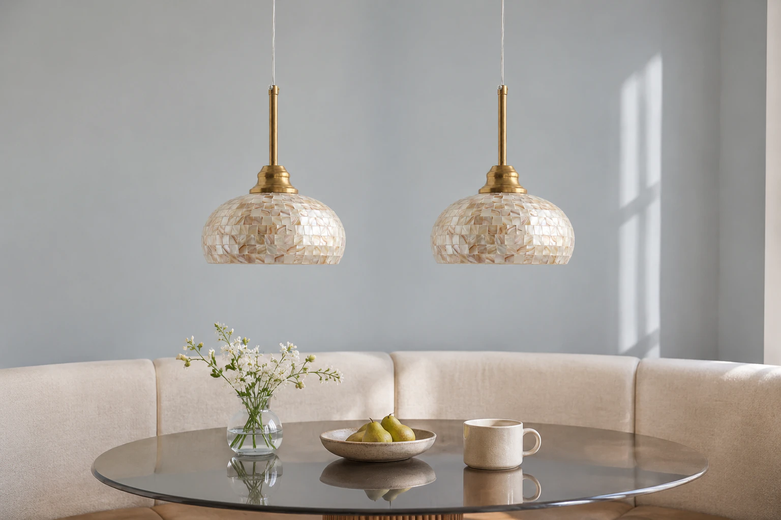 Two matching brass mother-of-pearl pendants above a breakfast table