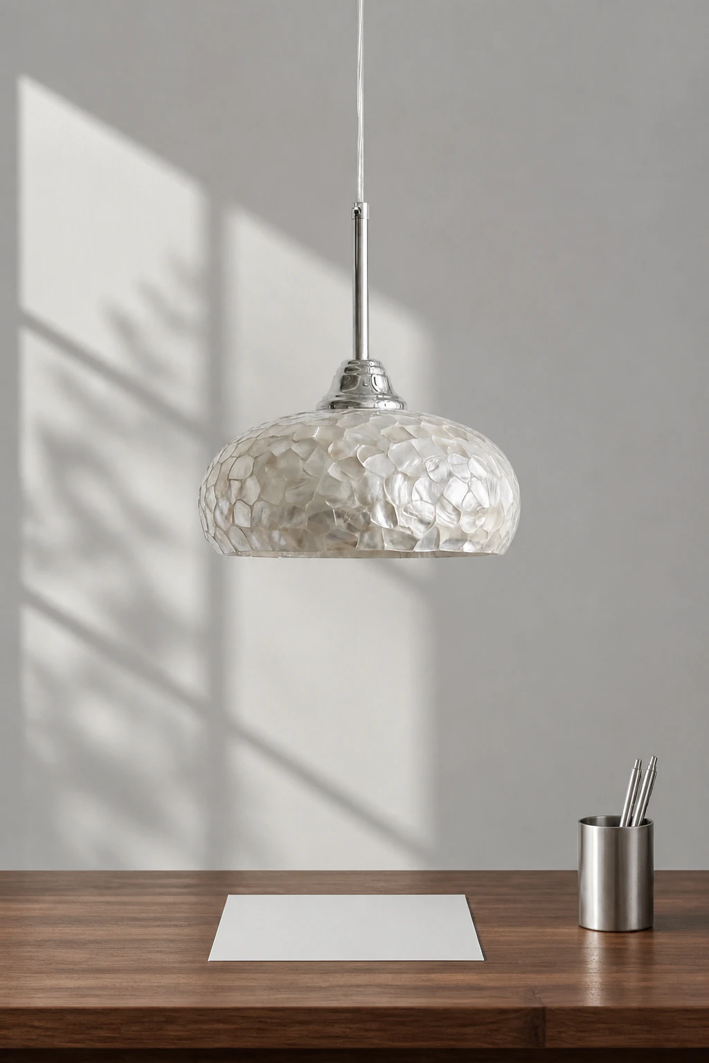 Complete chrome mother-of-pearl pendant above a writing surface