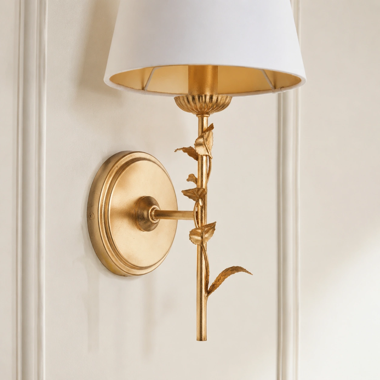 Round distressed gold leaf backplate mounted flush to the wall with the short arm level