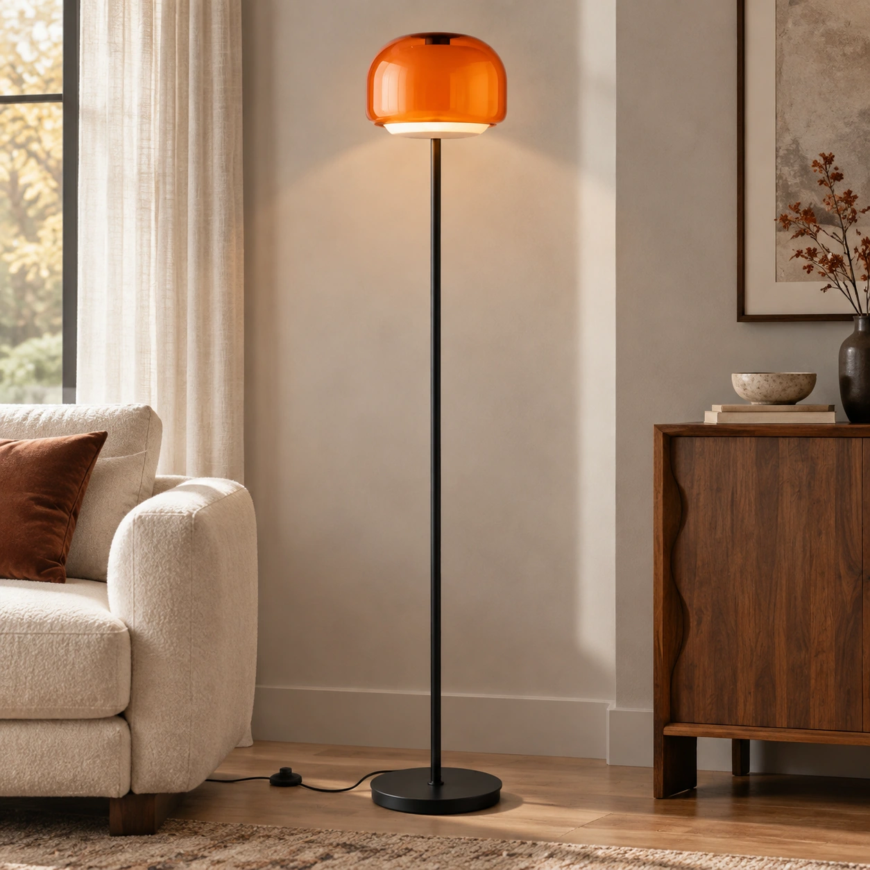 Full orange Sanae floor lamp showing the round glass shade, slim black stem and circular base