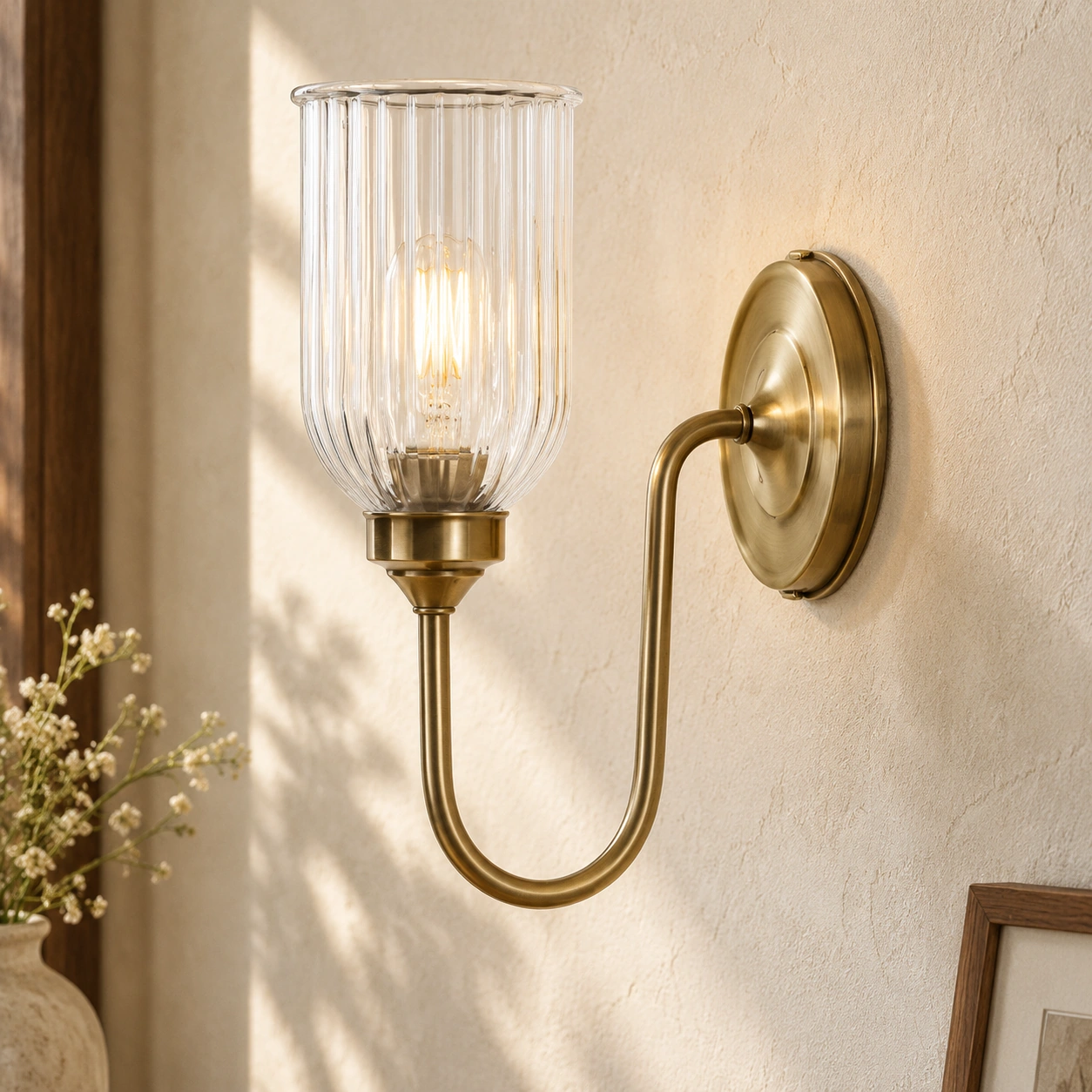 Close view of the Menae clear vertically ribbed glass shade and antique brass holder