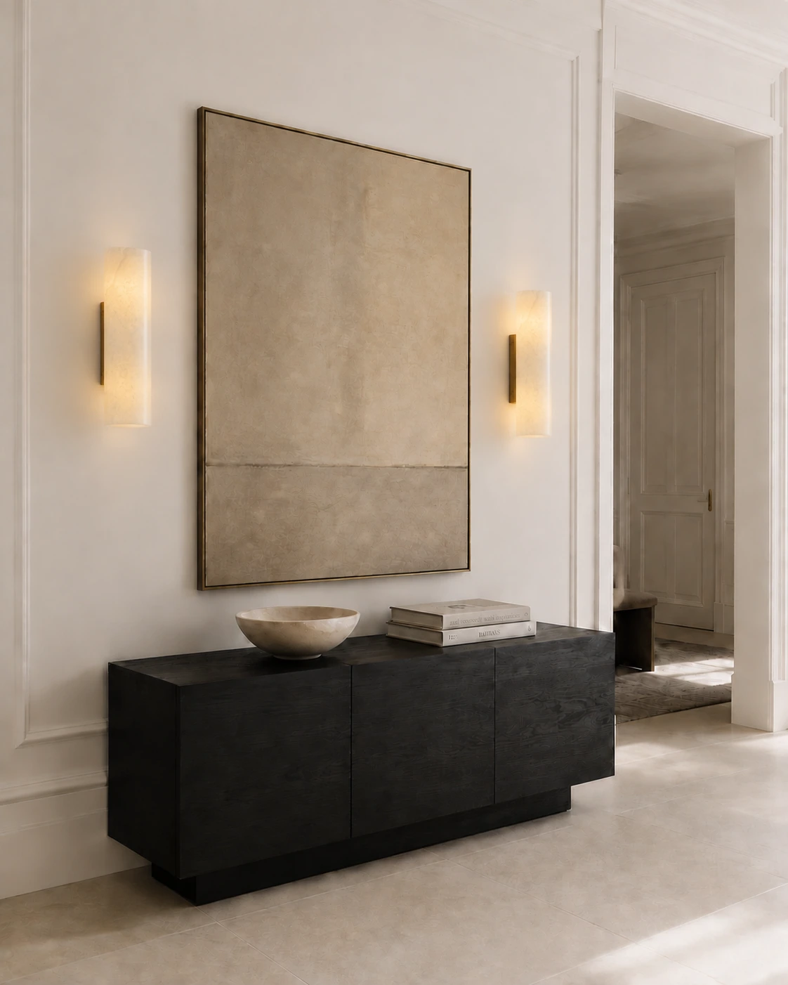 Pair of Brass Doran sconces framing art in a gallery-like entry