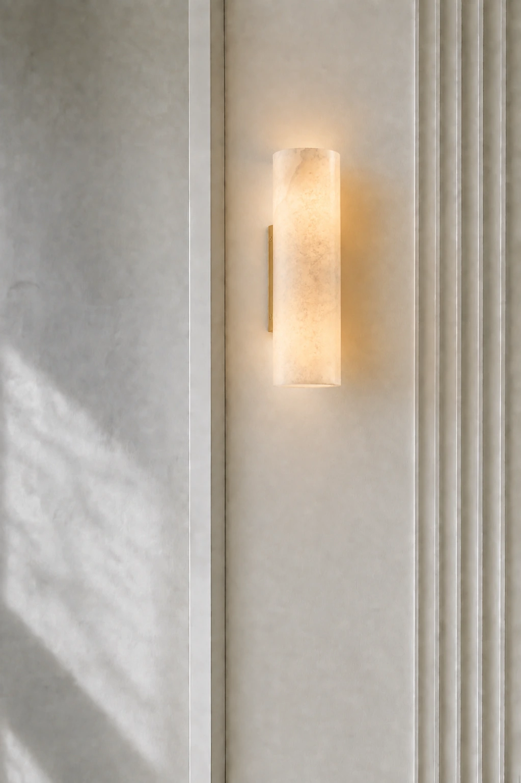 Single Brass Doran sconce on restrained fluted white plaster
