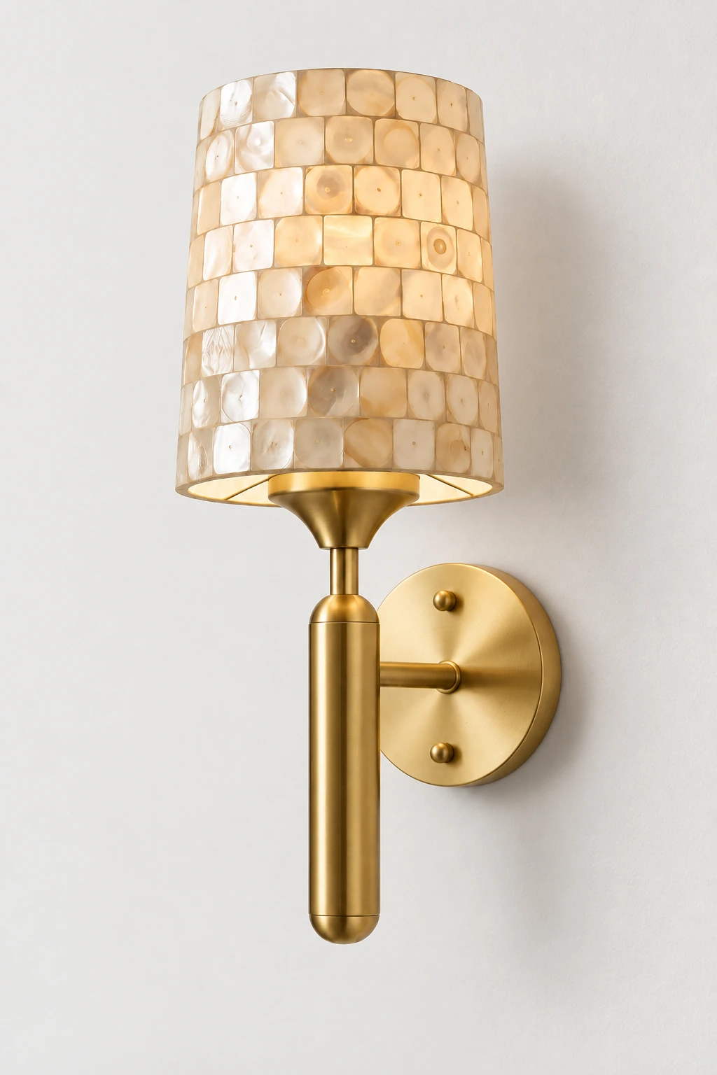 Complete brass shell-mosaic wall sconce mounted on a neutral studio wall