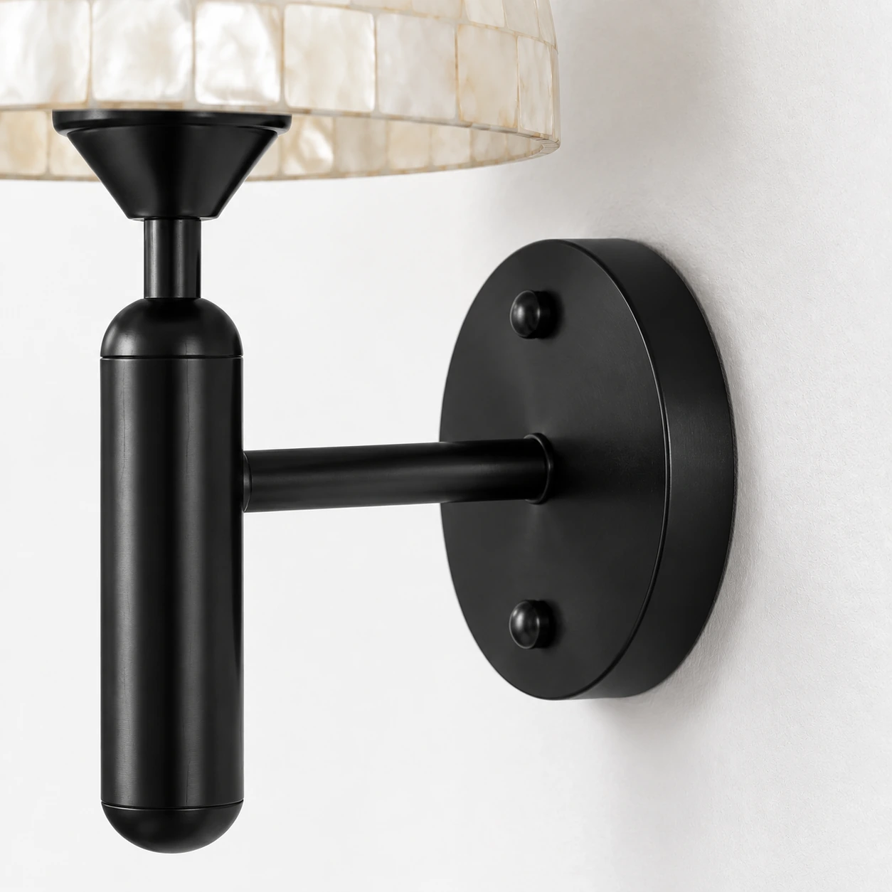 Black circular wall plate and projecting arm in a close side view