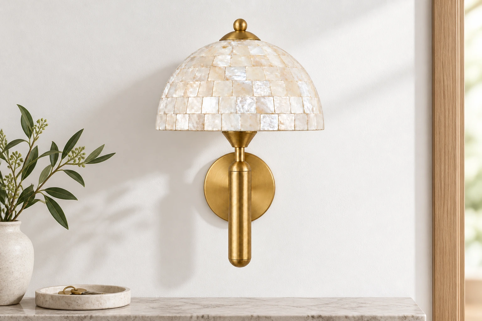 Gold shell wall sconce above a narrow entryway ledge