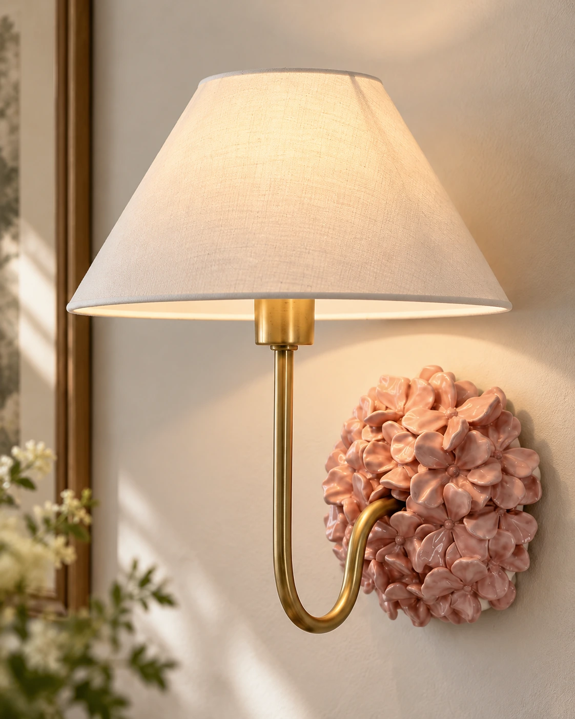 Ivory tapered linen shade and gold-toned curved arm on the Florienne pink wall sconce