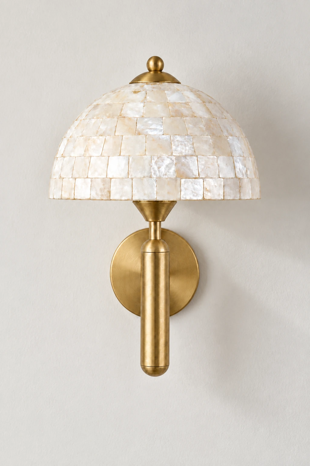 Complete gold shell dome wall sconce against a neutral studio wall