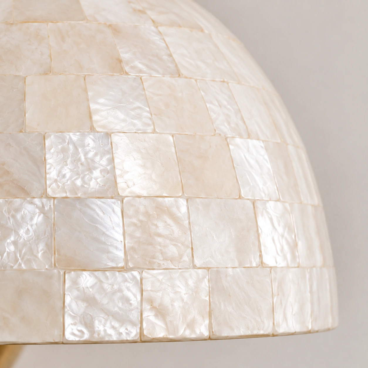 Close detail of the white shell mosaic and curved shade edge