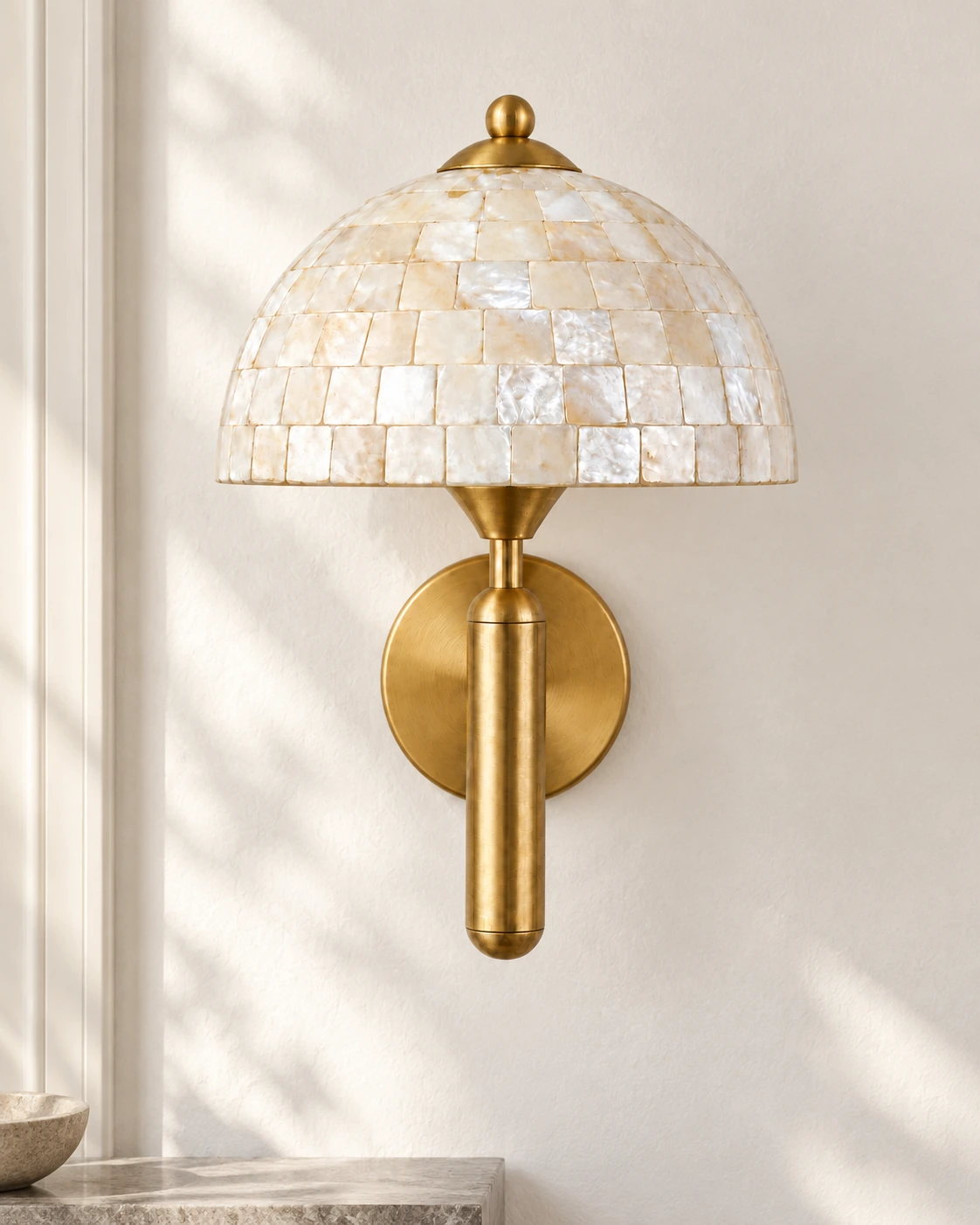 Complete gold shell dome wall sconce installed on a white wall