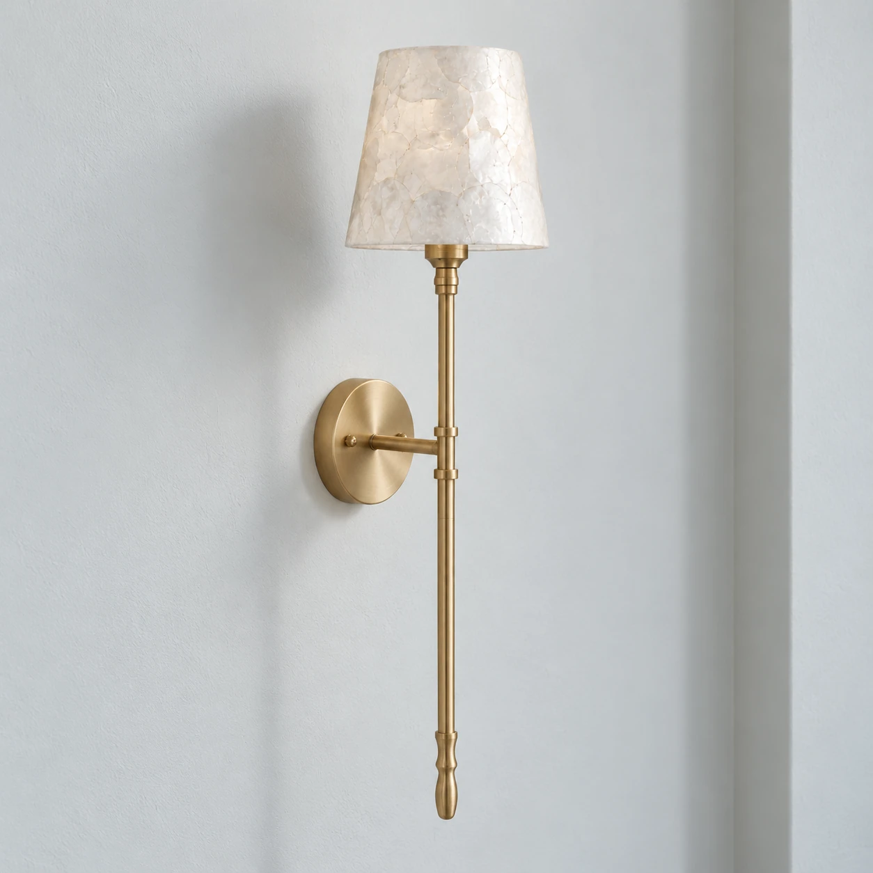 Complete slender brass wall sconce with a tapered shell shade and turned lower finial
