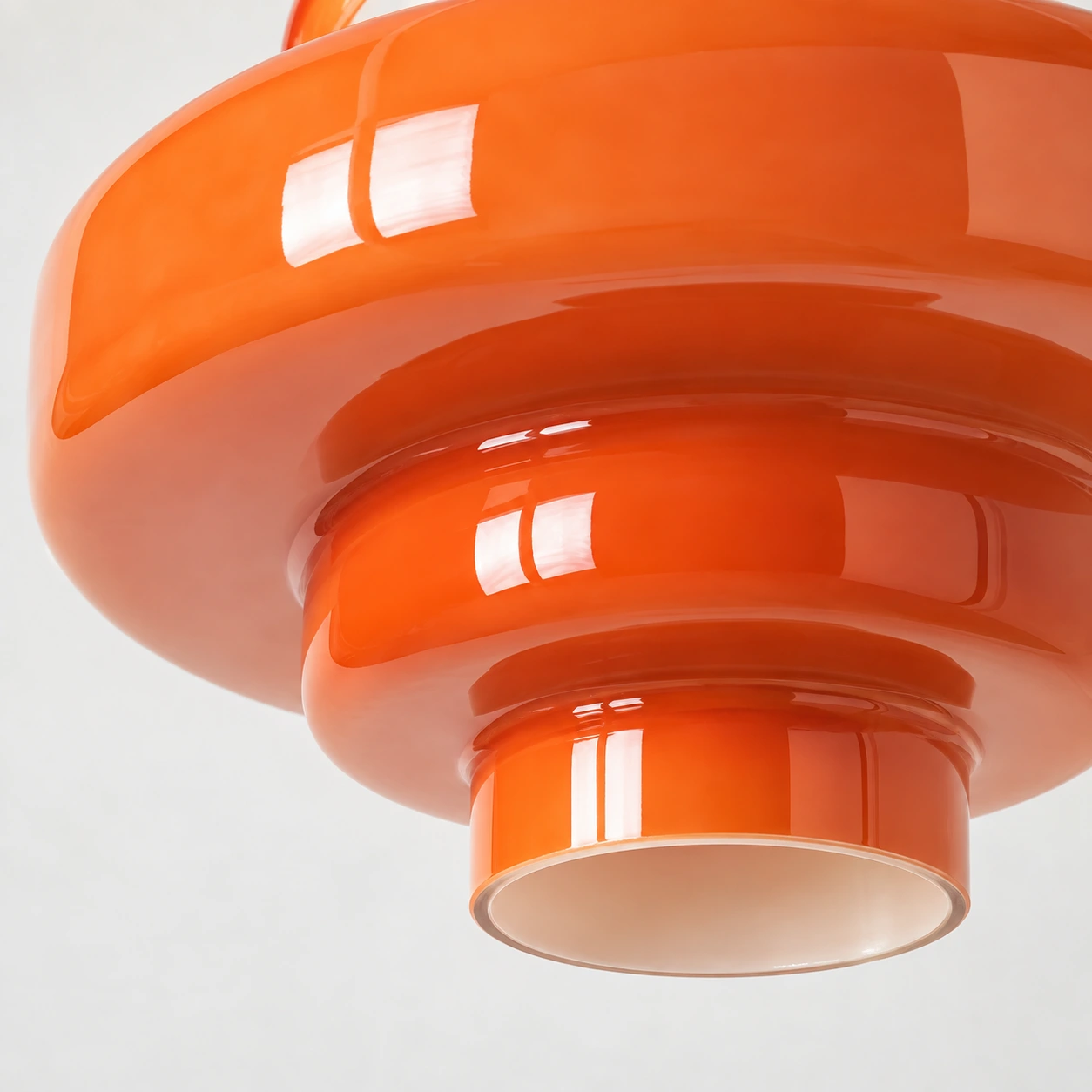Close-up of the glossy orange glass tiers and open lower rim