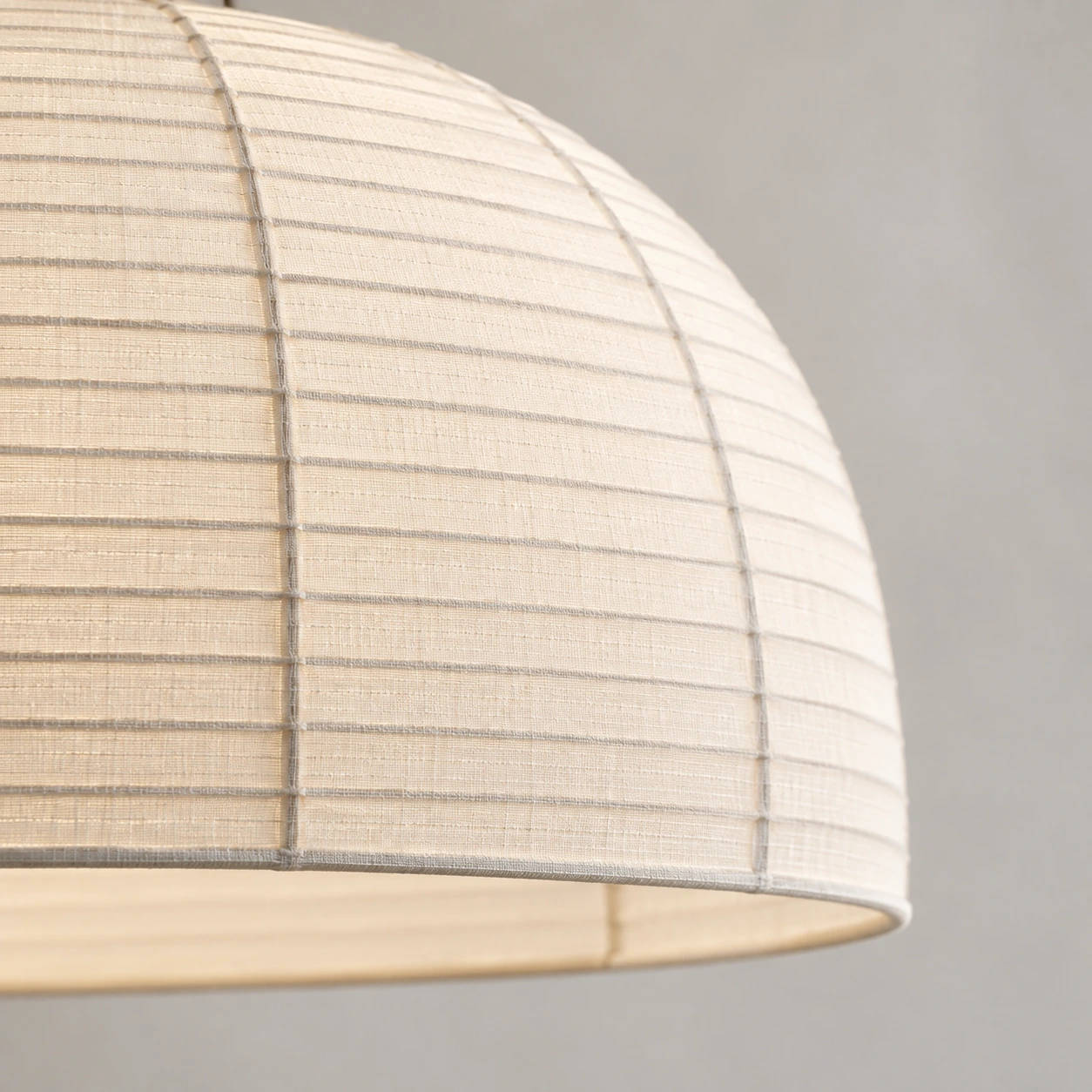 Close-up of the ivory gauze fabric and fine ribs along the curved pendant shade