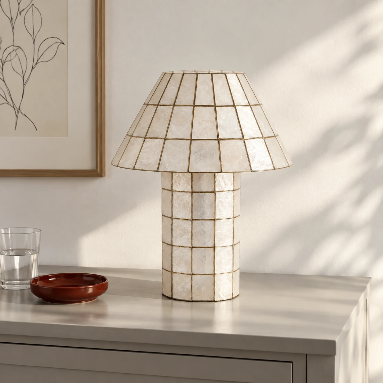 Full shell table lamp on a pale sideboard in daylight