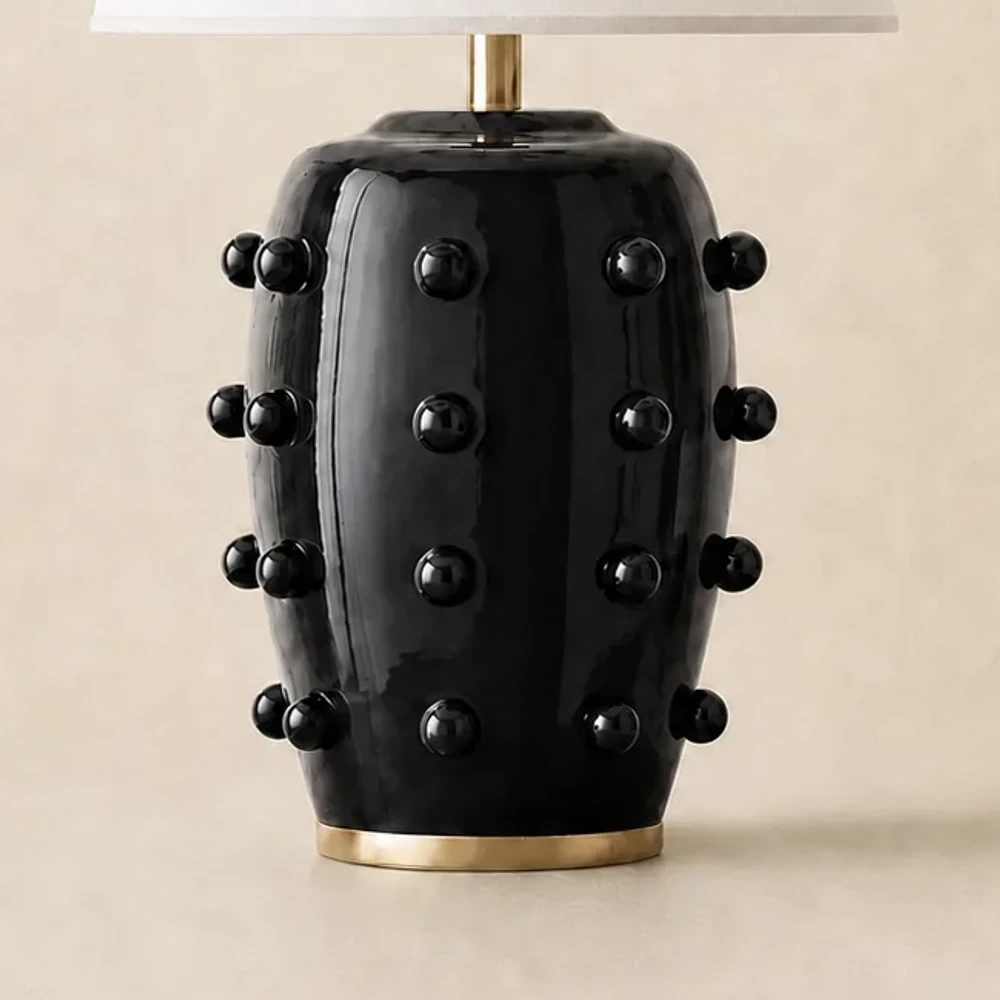 Close view of the black glazed porcelain body and brushed brass foot