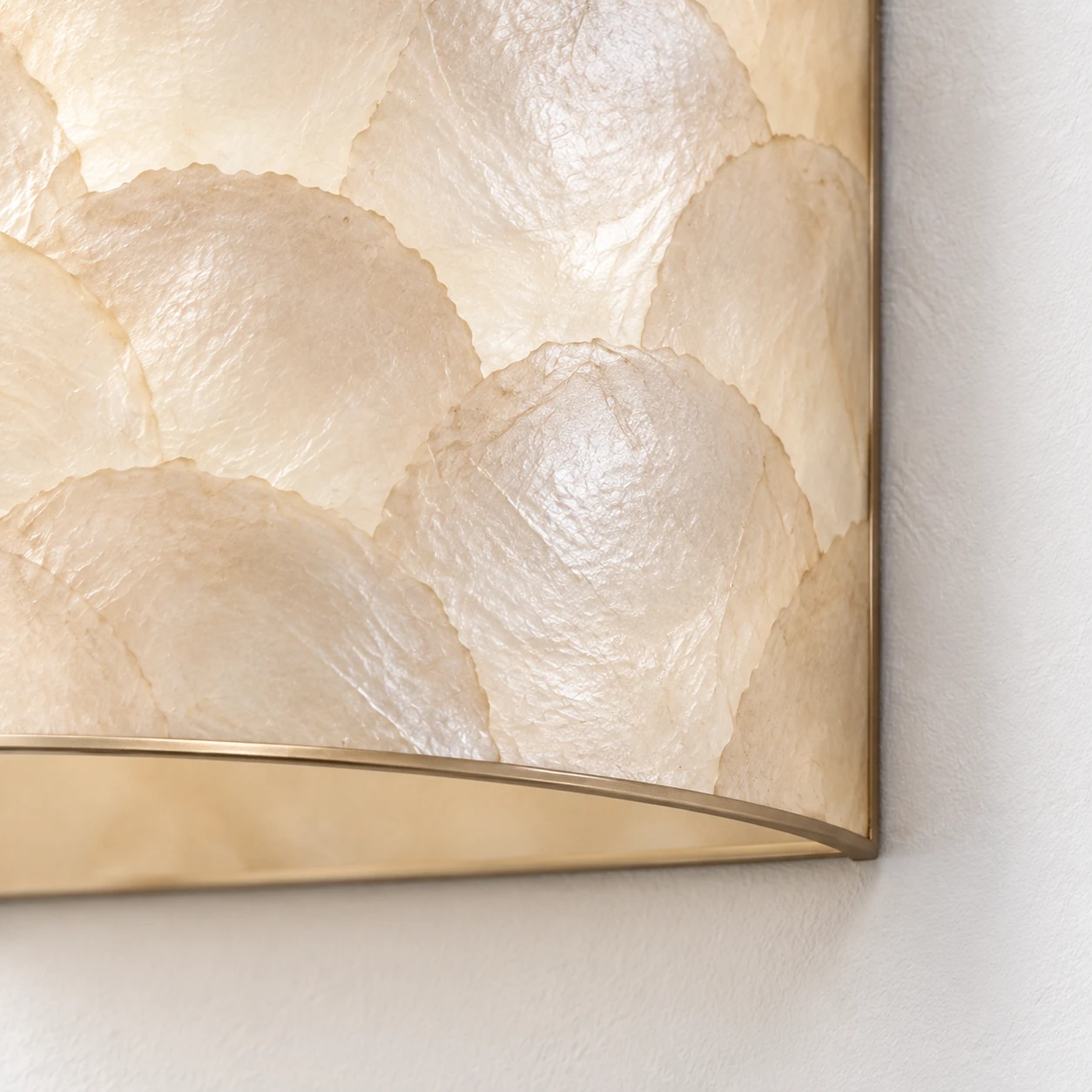 Close detail of layered shell meeting the lower champagne-toned rim