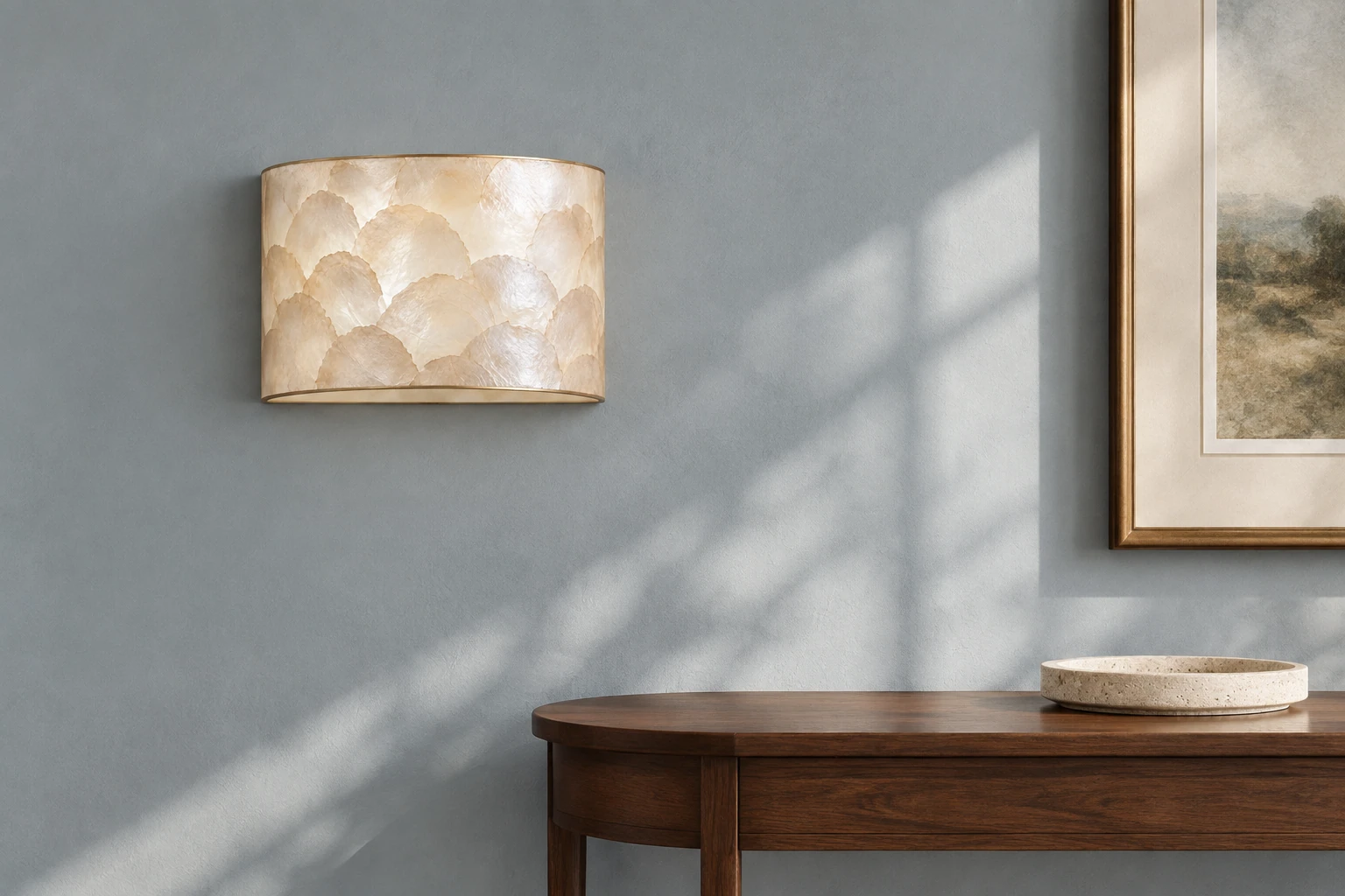 Aveline natural shell wall sconce on a slate-blue entryway wall