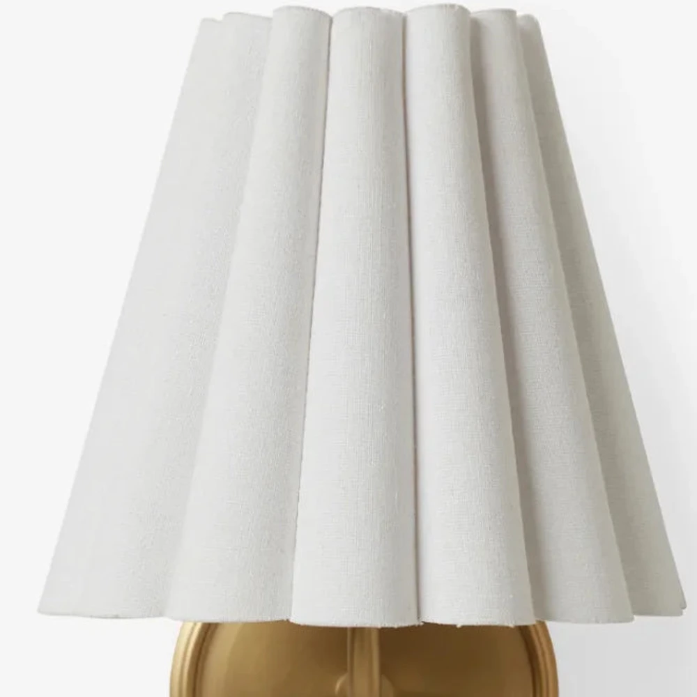 Close view of the tapered pleated linen wall sconce shade