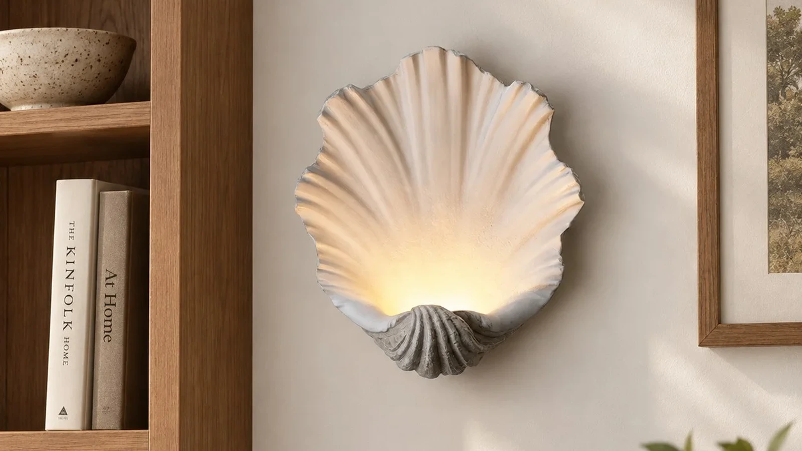 White sculptural seashell LED wall light above a natural wood console